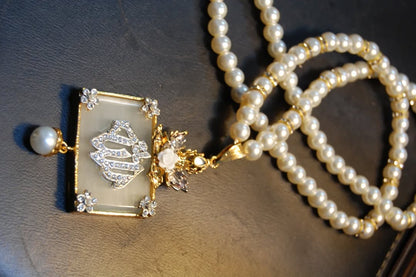 CALLIGRAPHIC PENDENT IN WHITE & PEARL STRING