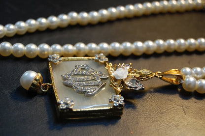 CALLIGRAPHIC PENDENT IN WHITE & PEARL STRING